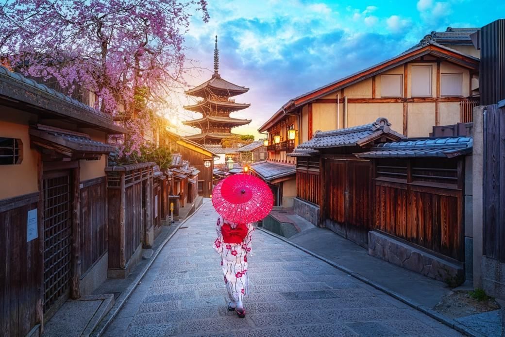 Woman with a red umbrella on a Higashiyama lane below the Yasaka Pagoda, Kyoto