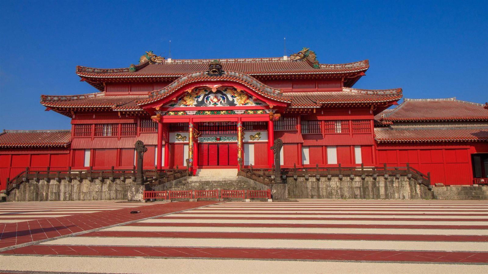 Red lacquered main hall of Shuri Castle under a blue sky, Okinawa