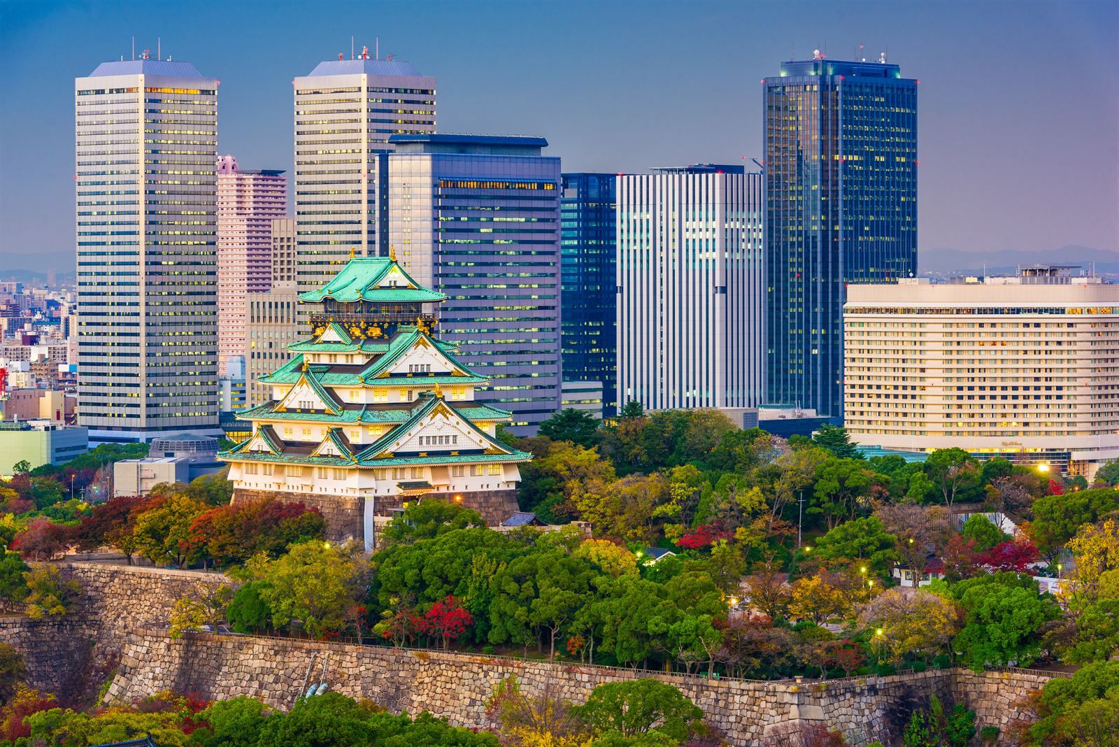 Osaka Castle keep on its stone walls, framed by modern towers