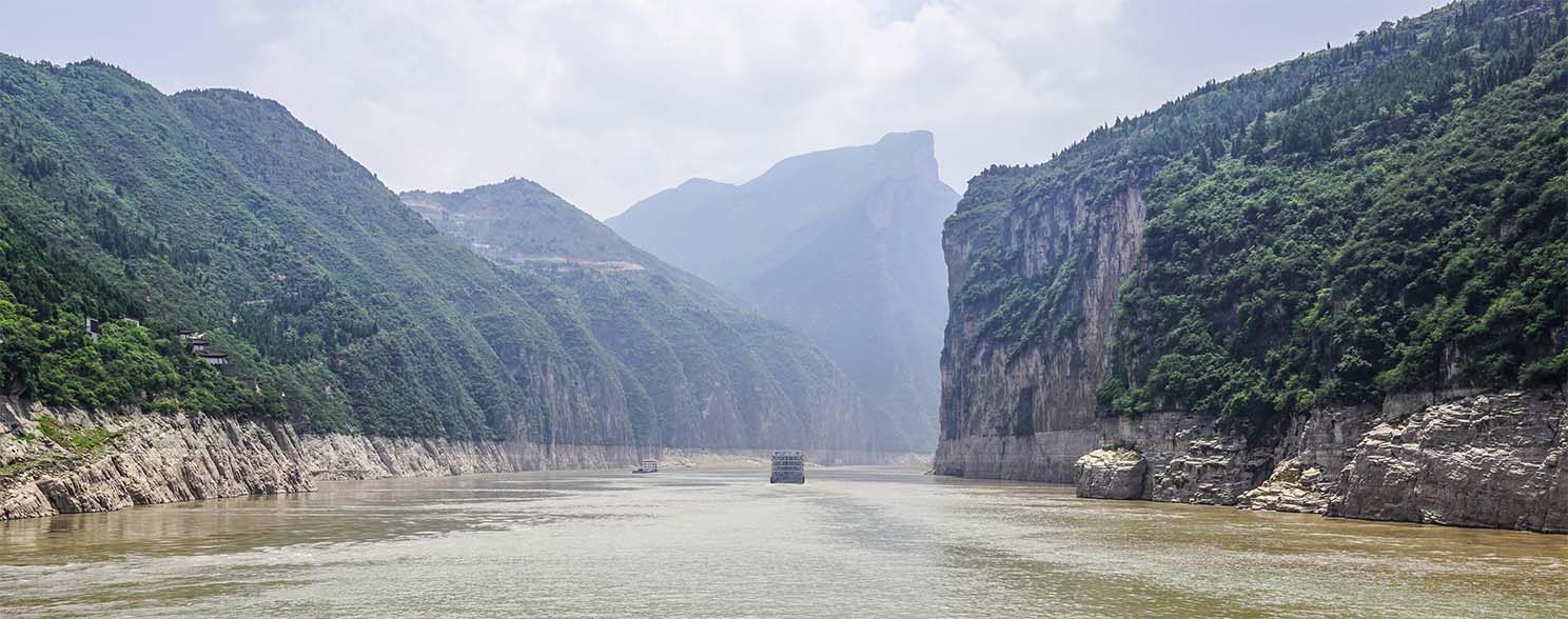 River ship sailing between the steep cliffs of the Three Gorges on the Yangtze